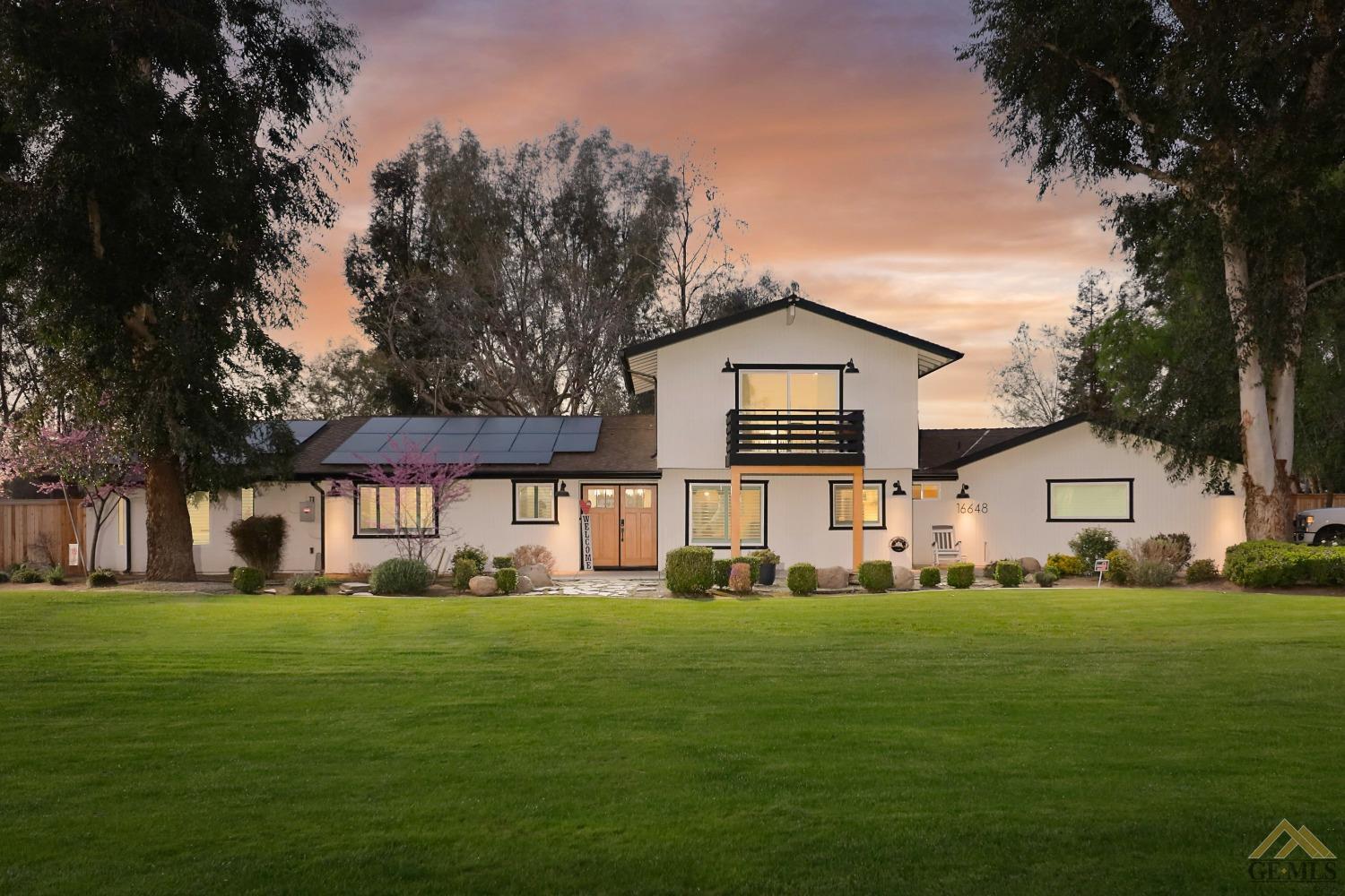 a front view of a house with a yard and trees