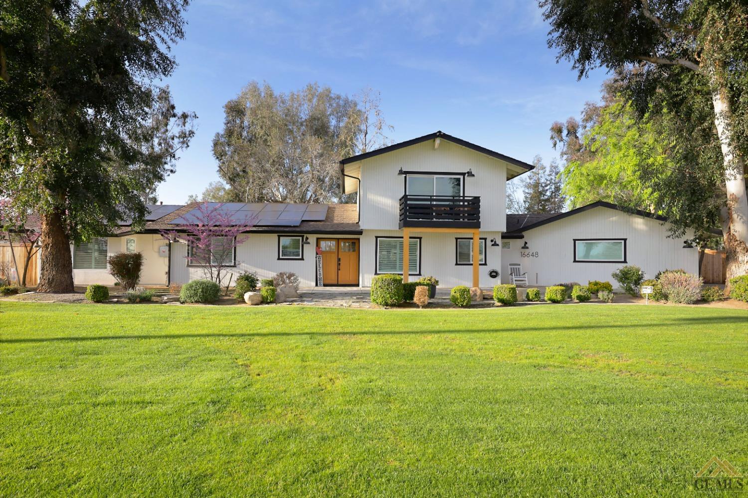 Undisclosed Address Bakersfield, CA 93314 - Photo 49 of 52 a front view of a house with a yard and trees