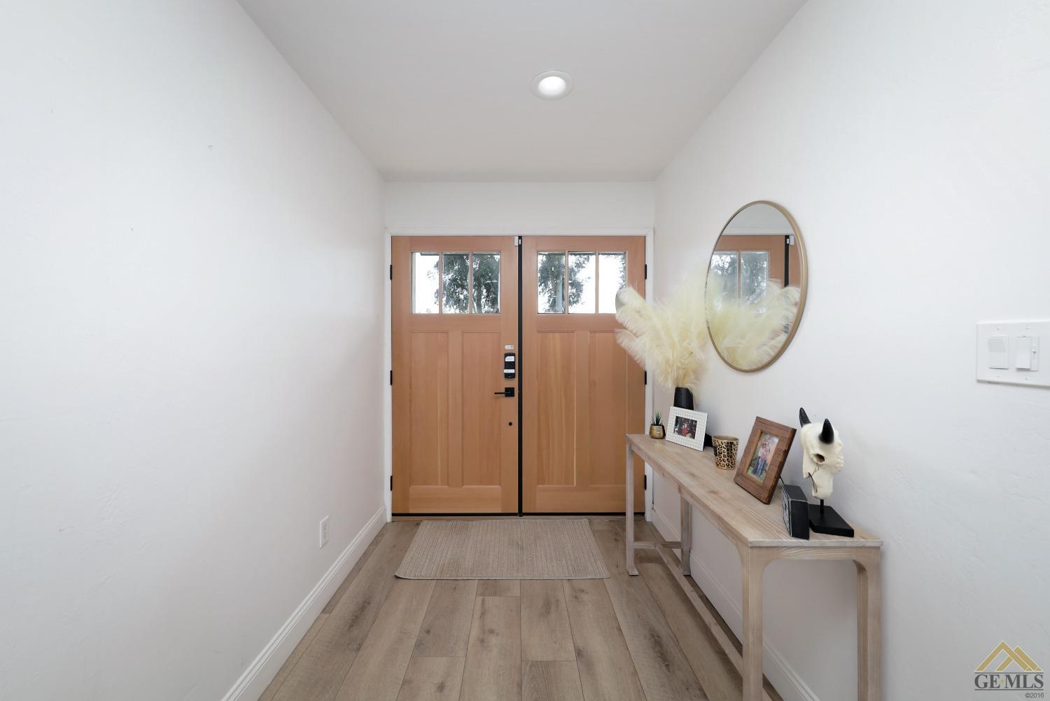 Undisclosed Address Bakersfield, CA 93314 - Photo 5 of 52 an entryway with wooden floor mirror and a wooden floor