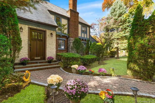 a front view of a house with a yard and fountain