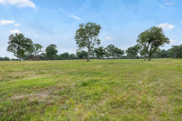 a view of a green field with wooden fence