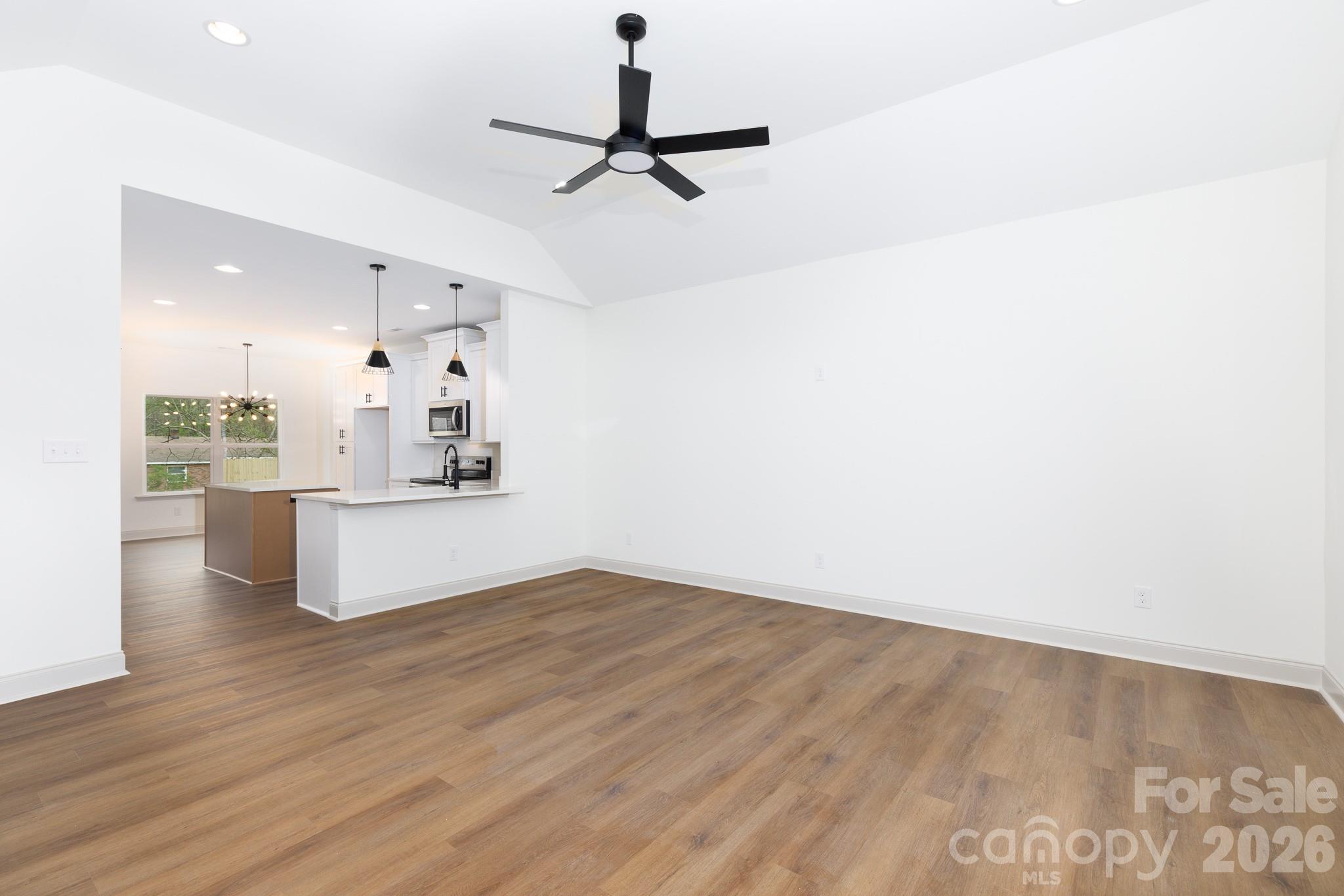 107 Brown Street, Unit 12 Clover, SC 29710 - Photo 5 of 33 a view of a kitchen with wooden floor and a ceiling fan