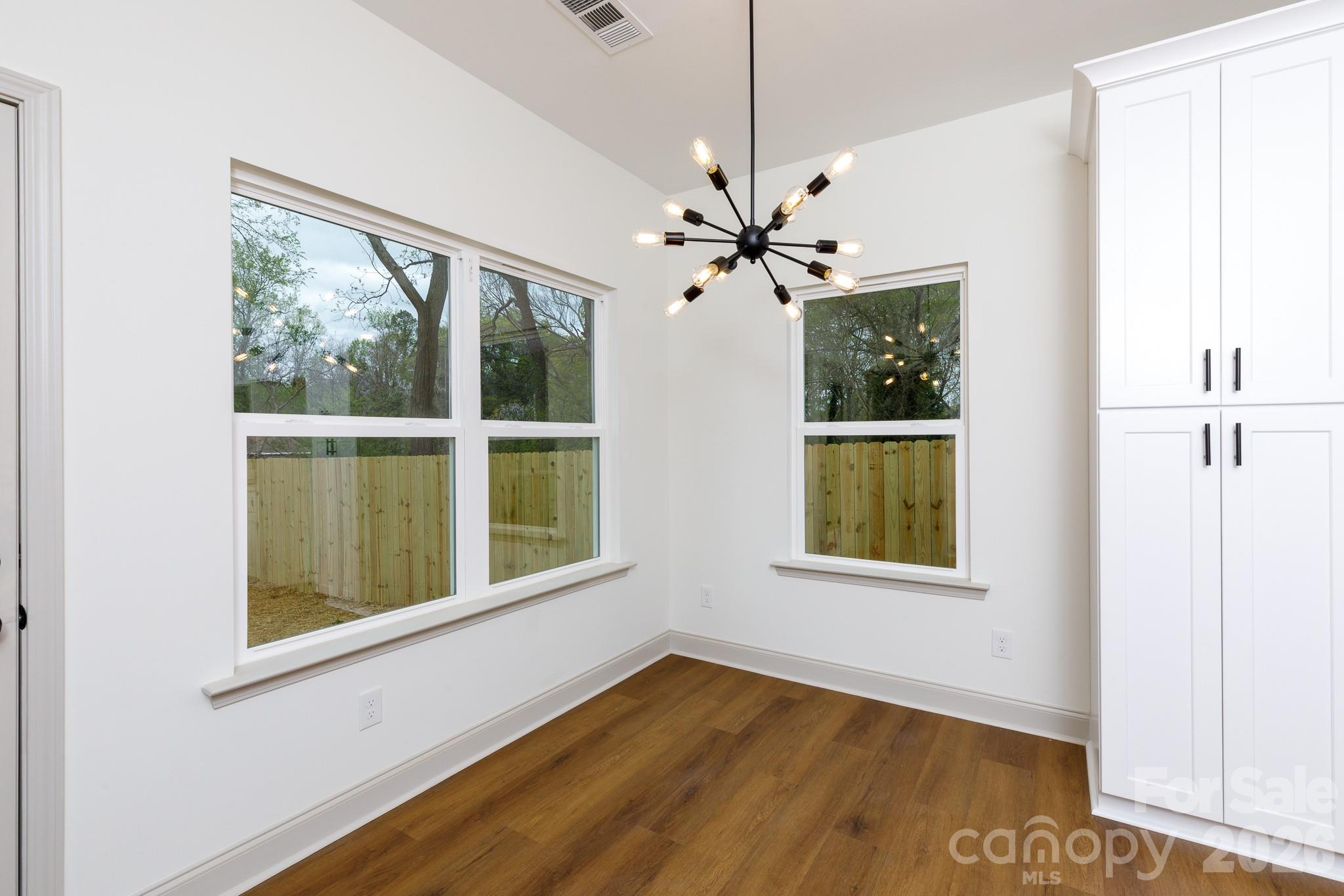 107 Brown Street, Unit 12 Clover, SC 29710 - Photo 8 of 33 a view of an empty room with a window and wooden floor
