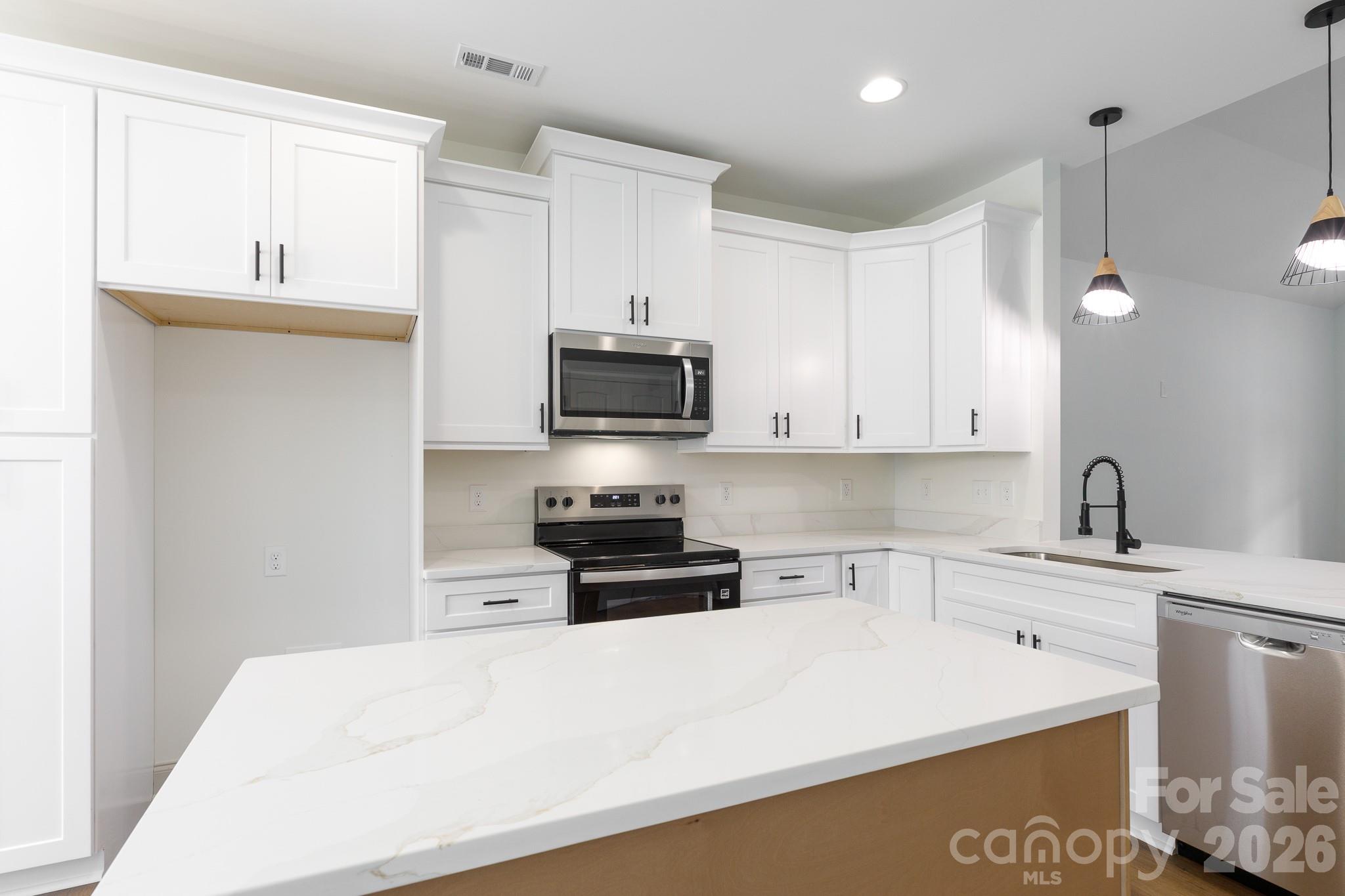 107 Brown Street, Unit 12 Clover, SC 29710 - Photo 10 of 33 a kitchen with stainless steel appliances a sink a stove a microwave a sink a refrigerator and cabinets
