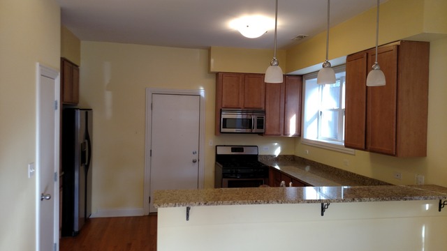 1542 West Sherwin Avenue, Unit GS Chicago, IL 60626 - Photo 2 of 11 a kitchen with stainless steel appliances granite countertop a refrigerator and a stove top oven