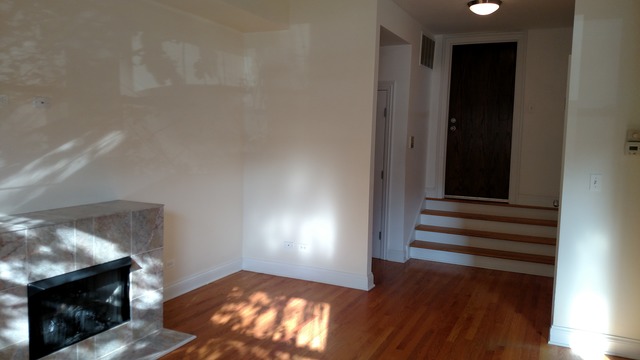1542 West Sherwin Avenue, Unit GS Chicago, IL 60626 - Photo 11 of 11 a view of an empty room with wooden floor and a fireplace