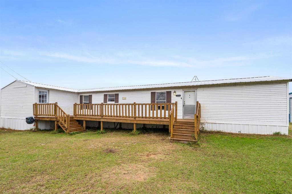 a view of a house with a backyard and deck