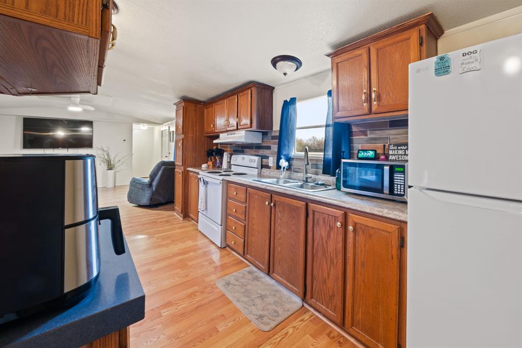 1304 Rains County Road 1530 Point, TX 75472 - Photo 12 of 40 a kitchen with stainless steel appliances granite countertop a refrigerator a sink dishwasher a stove with wooden cabinets