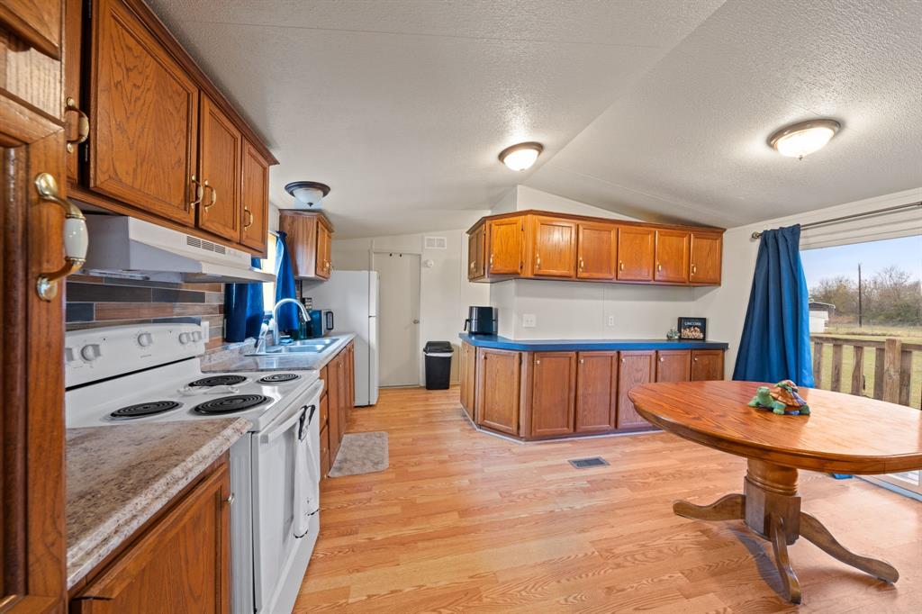 1304 Rains County Road 1530 Point, TX 75472 - Photo 8 of 40 a kitchen with stainless steel appliances granite countertop a stove a sink and a refrigerator