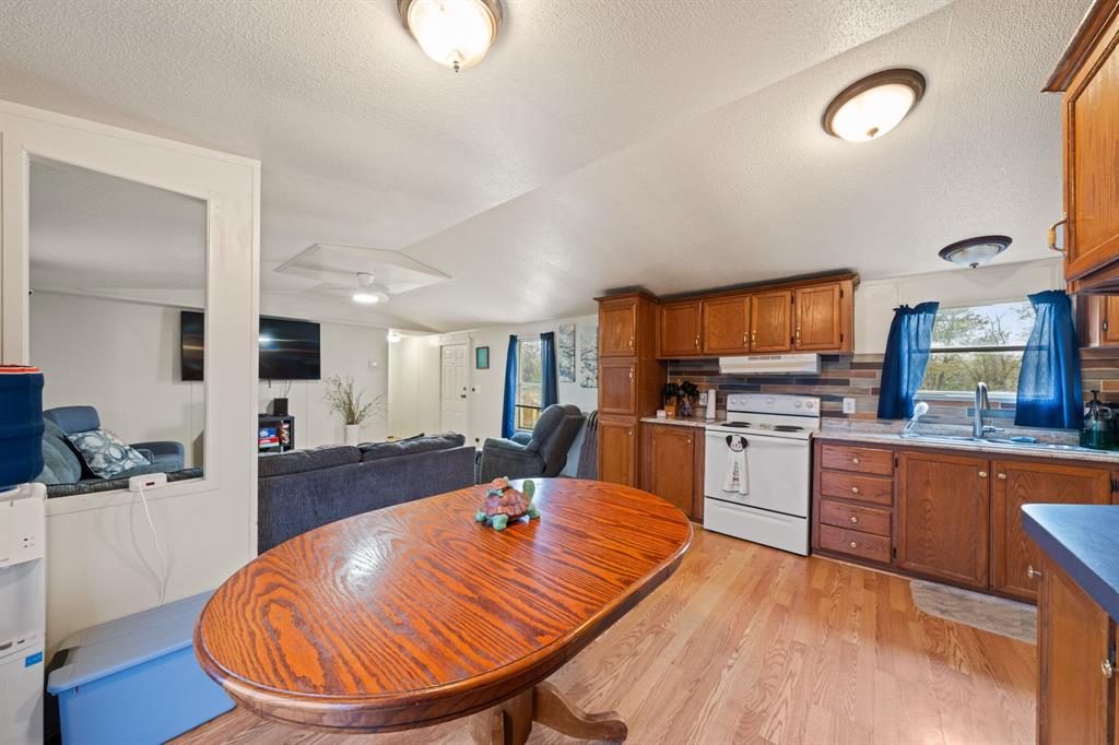 1304 Rains County Road 1530 Point, TX 75472 - Photo 9 of 40 a kitchen with stainless steel appliances wooden floor dining table and chairs