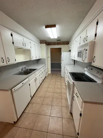 a kitchen with stainless steel appliances a sink a stove a microwave and cabinets