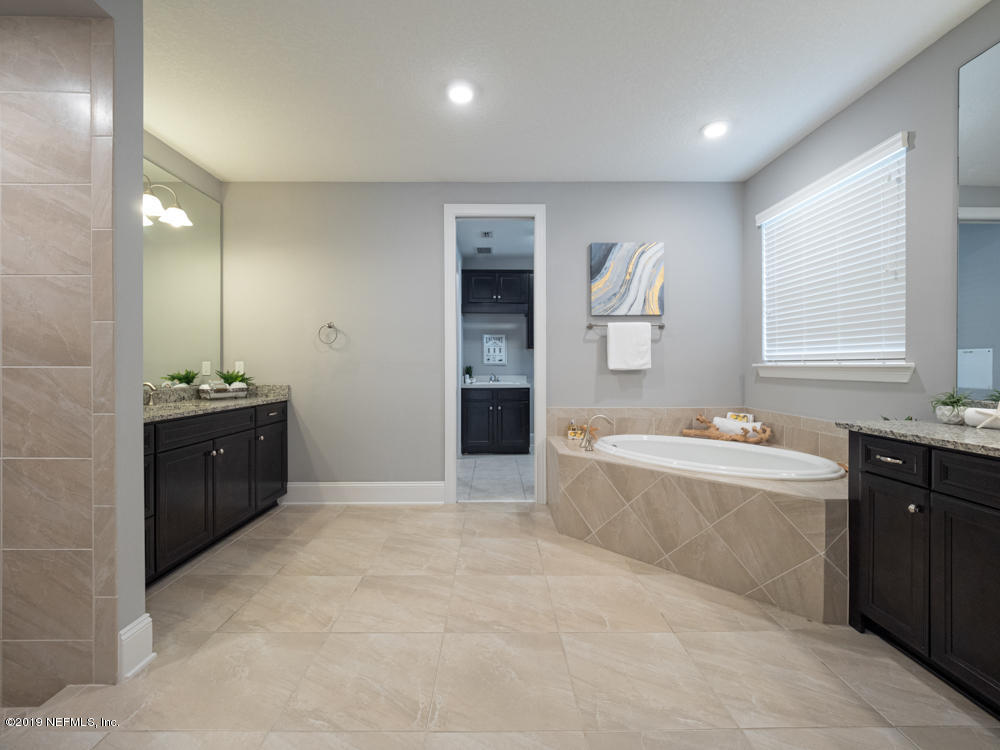 743 Cross Ridge Drive Ponte Vedra, FL 32081 - Photo 32 of 83 a large bathroom with a tub sink and mirror