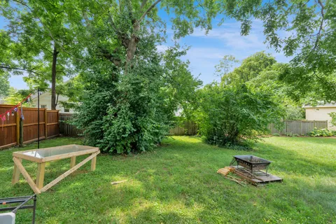 a backyard of a house with a table and chairs