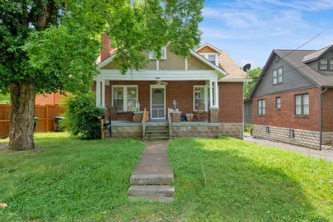 a front view of a house with a yard and trees