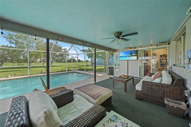 a living room with furniture and a floor to ceiling window