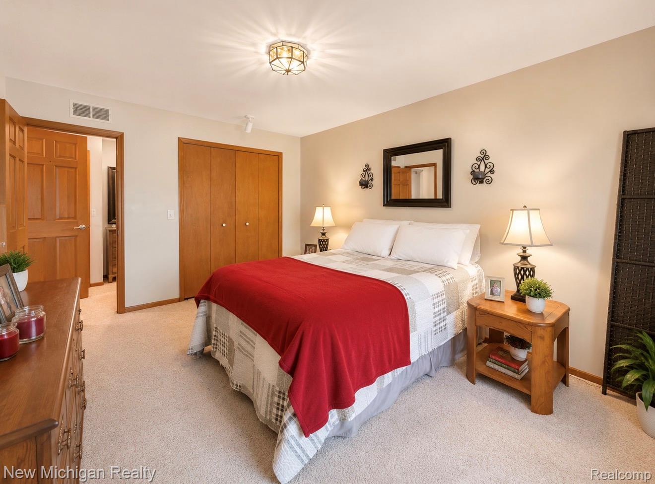 7156 East River Road Flushing, MI 48433 - Photo 20 of 35 Carpeted bedroom featuring light beige walls and natural wood-finish trim and doors