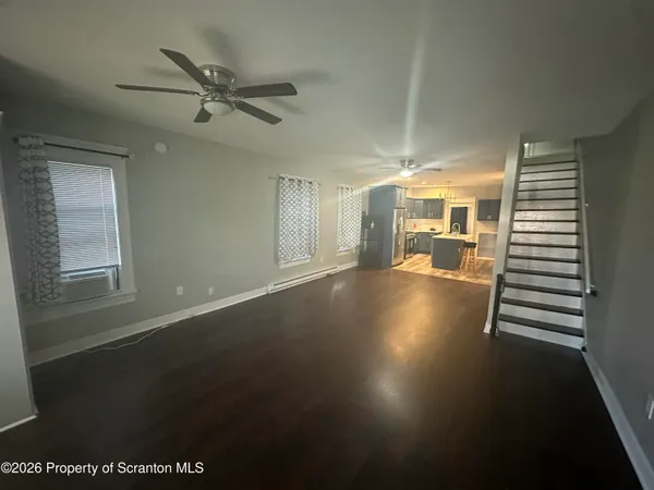 a view of a livingroom with furniture wooden floor and a window