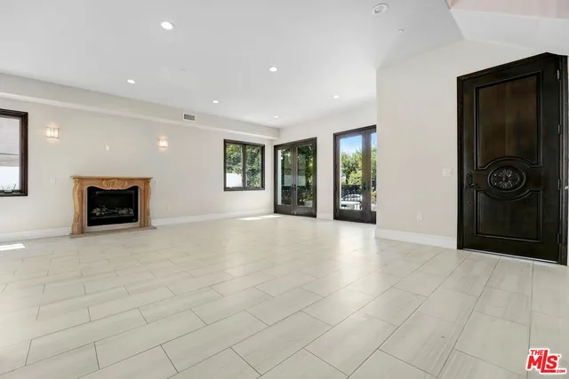 an empty room with entrance and windows