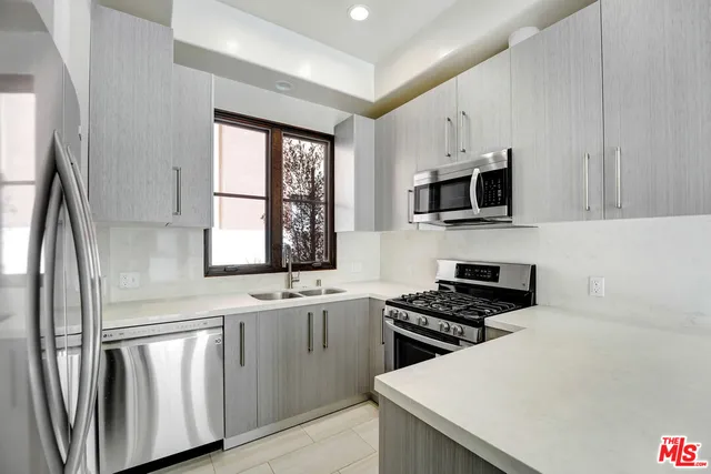 a kitchen with stainless steel appliances granite countertop a stove a sink and a microwave