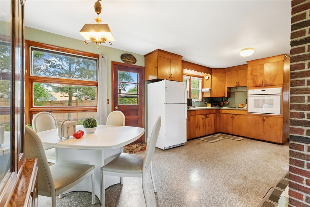 8 Everett Street Wakefield, MA 01880 - Photo 17 of 32 a kitchen with stainless steel appliances a refrigerator a sink a dining table and chairs