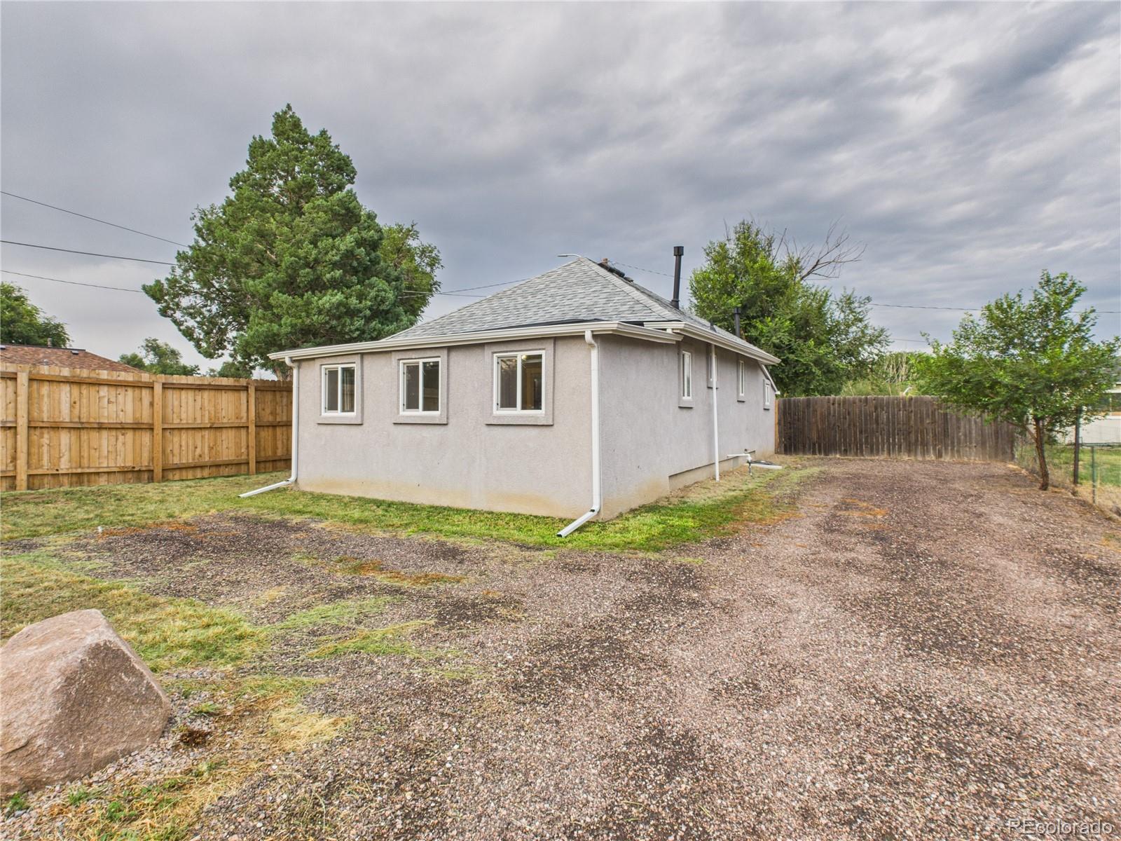 a backyard of a house with plants and trees