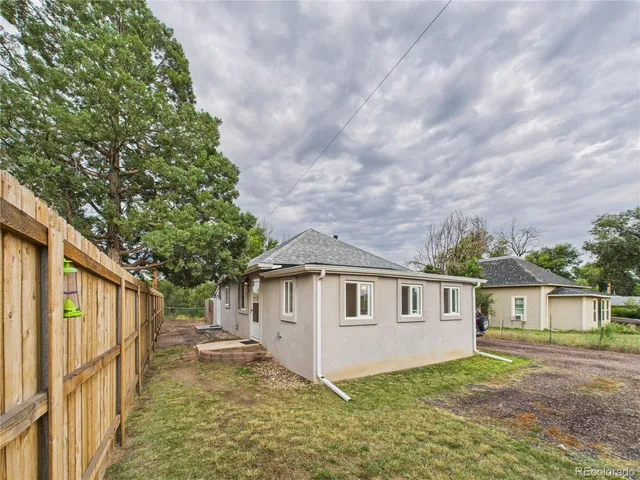 a view of a yard in front of a house with large tree