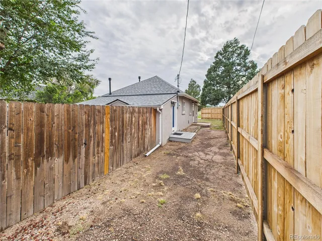a view of a backyard with wooden fence