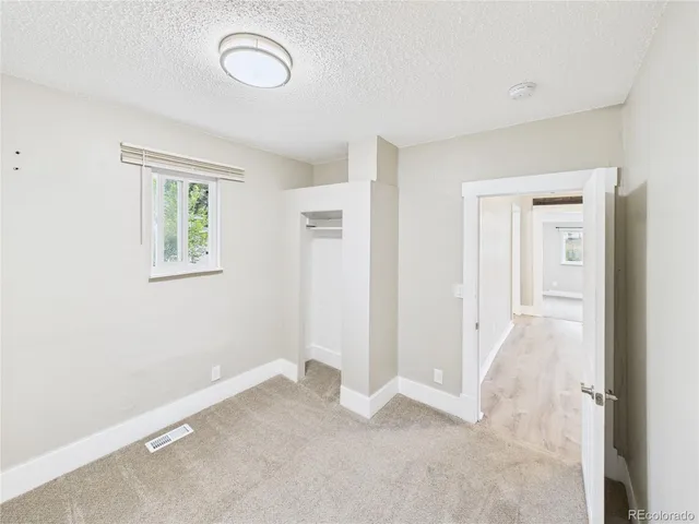 an empty room with windows and closet