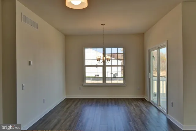 a view of kitchen with refrigerator and wooden floor