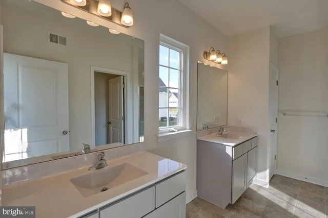 a bathroom with a sink double vanity and a mirror