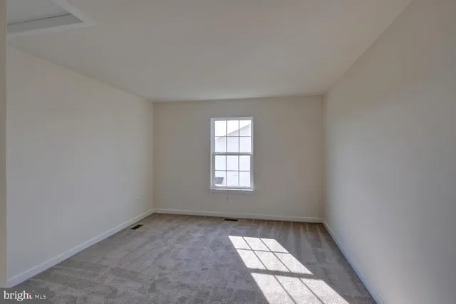 a view of empty room with refrigerator