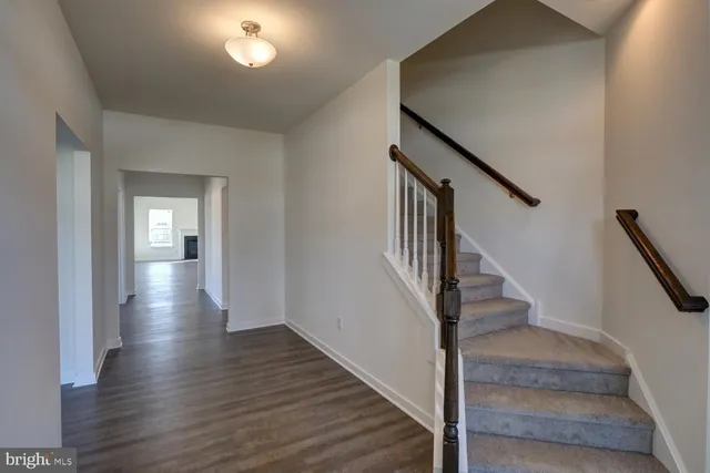 a view of staircase with wooden floor and white walls