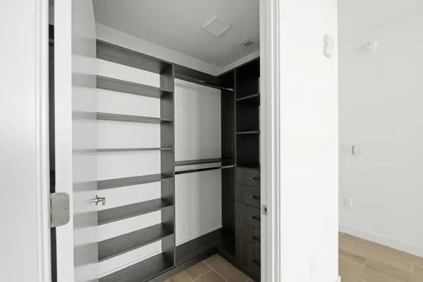 a view of walk in closet with empty racks