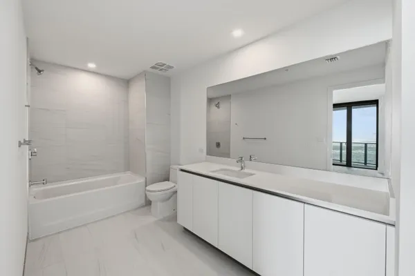 a spacious bathroom with a shower sink mirror and toilet