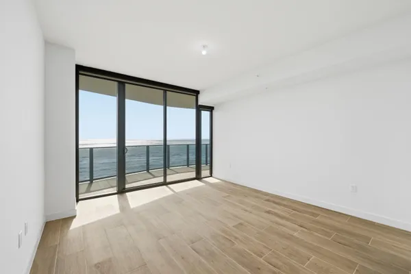 a view of a hallway with wooden floor and closet