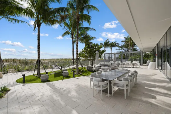 a view of a big room with windows and chandelier fan
