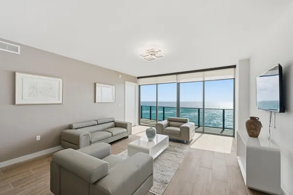 a living room with furniture large windows and a flat screen tv