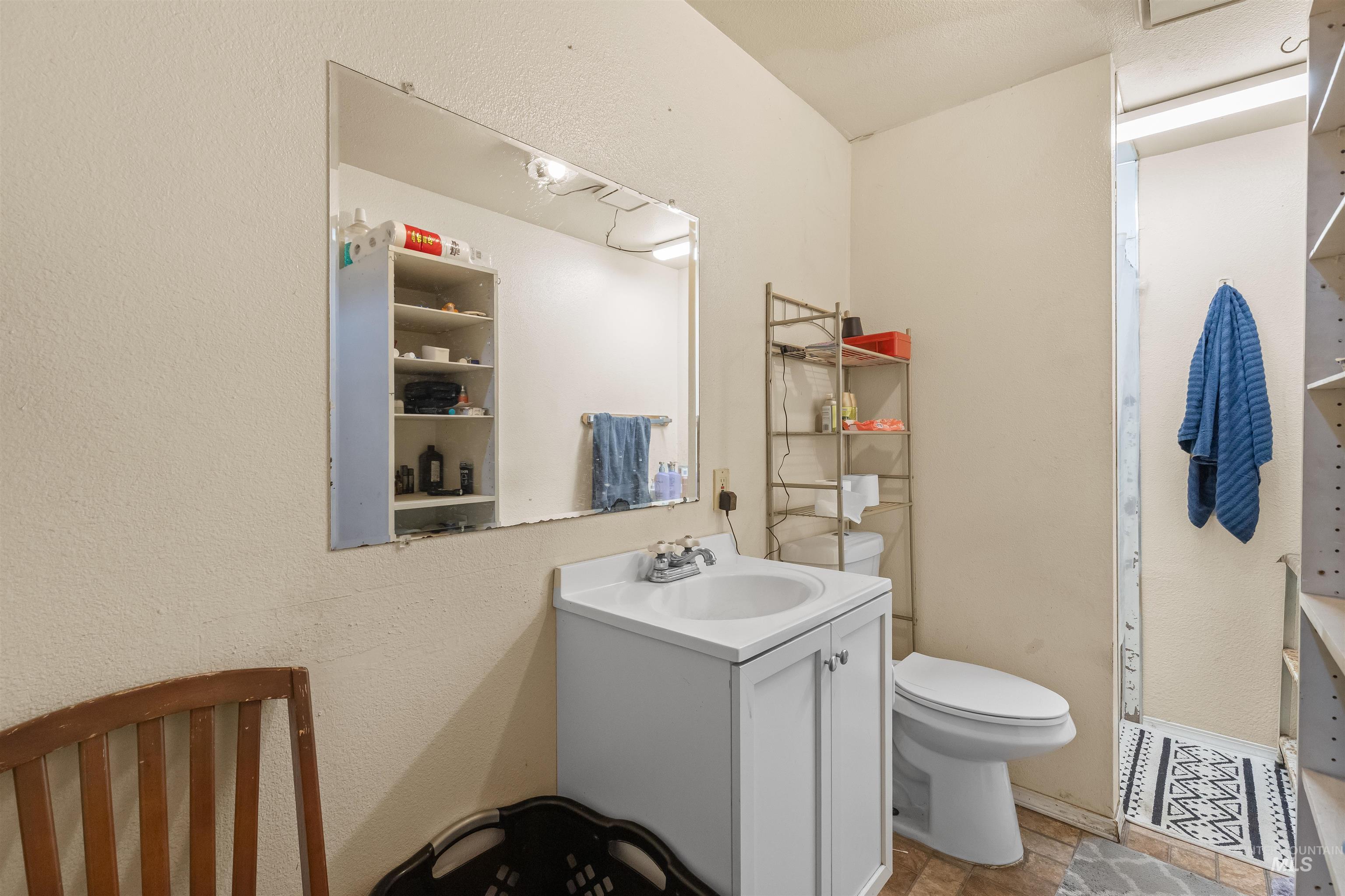 2460 State Street Pomeroy, WA 99347 - Photo 15 of 18 Bathroom featuring a white vanity with integrated sink, a commode, and a large wall-mounted mirror