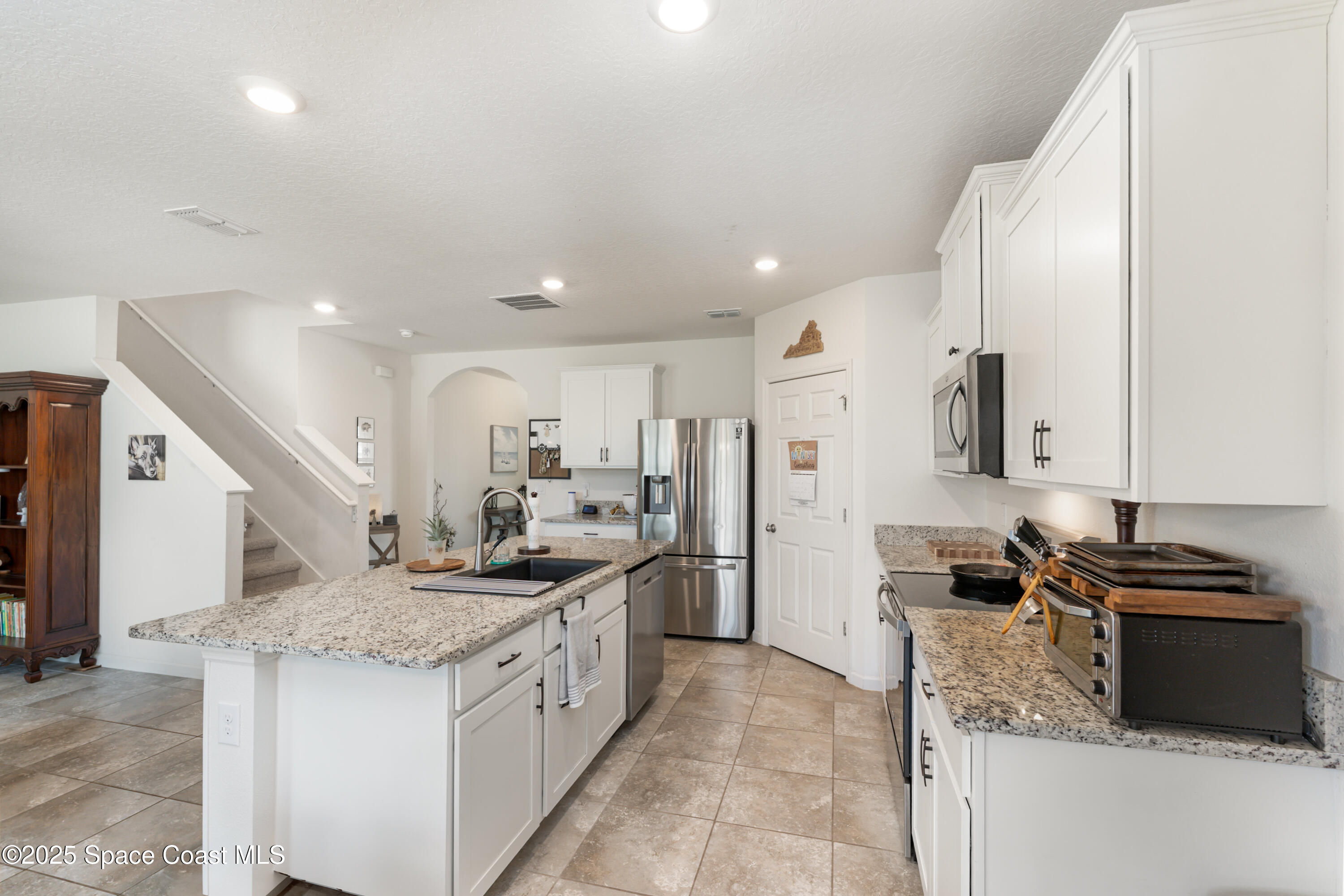 904 Old Country Rd S East Palm Bay, FL 32909 - Photo 7 of 25 a kitchen with a sink stove and refrigerator