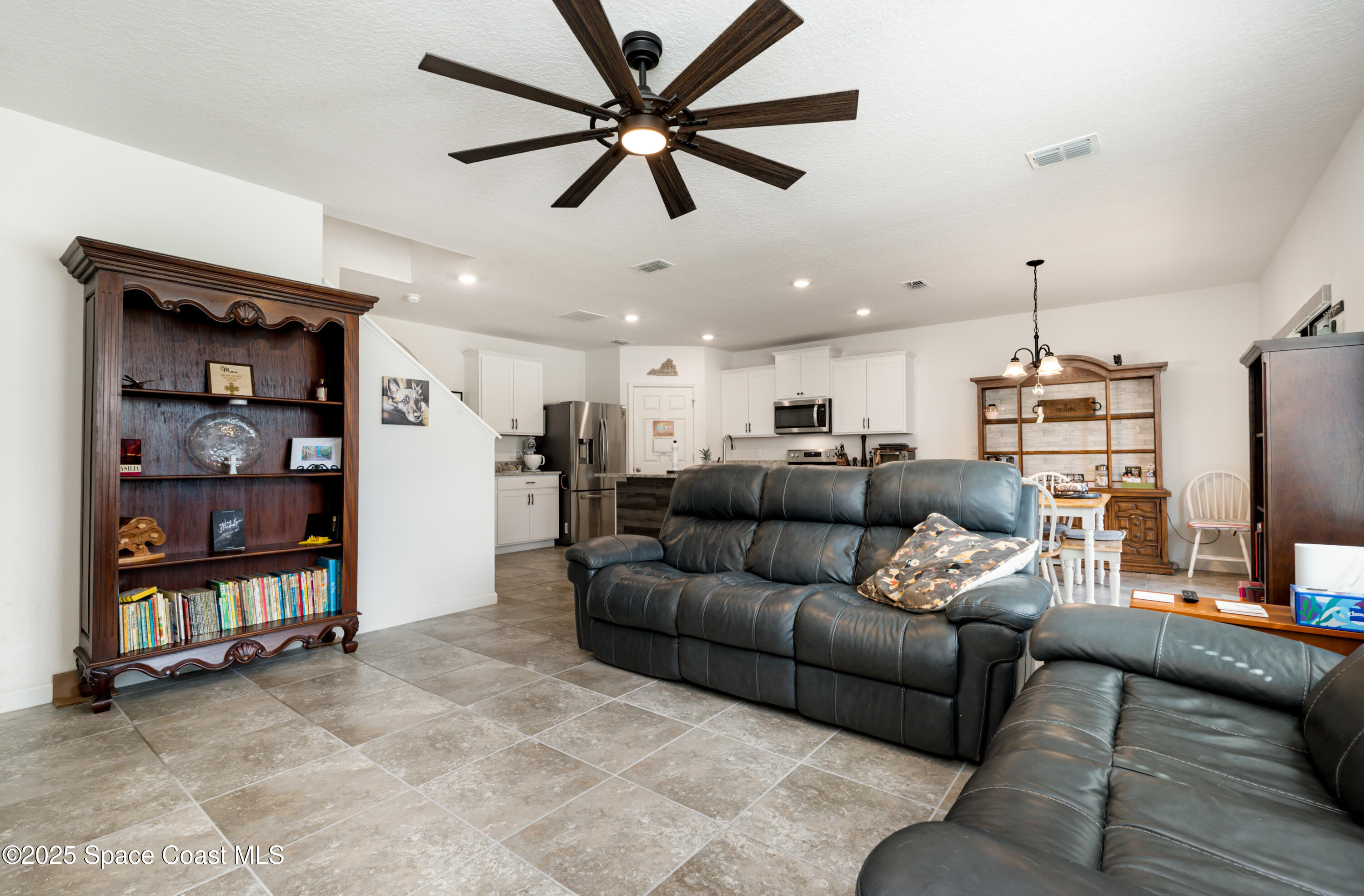 904 Old Country Rd S East Palm Bay, FL 32909 - Photo 9 of 25 a living room with furniture a ceiling fan and a flat screen tv