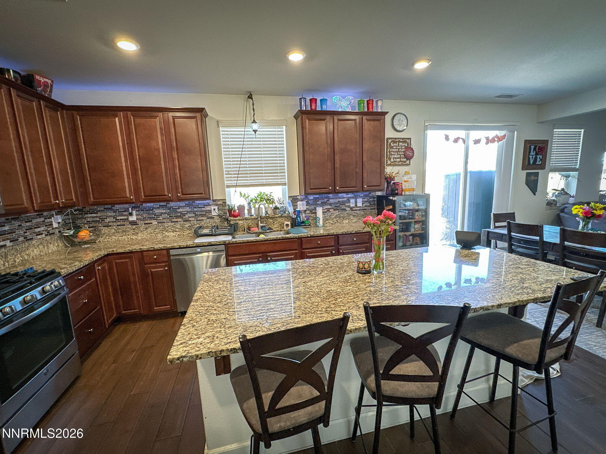 7330 Overture Drive Reno, NV 89506 - Photo 3 of 17 a kitchen with stainless steel appliances granite countertop a stove top oven a sink a dining table and chairs