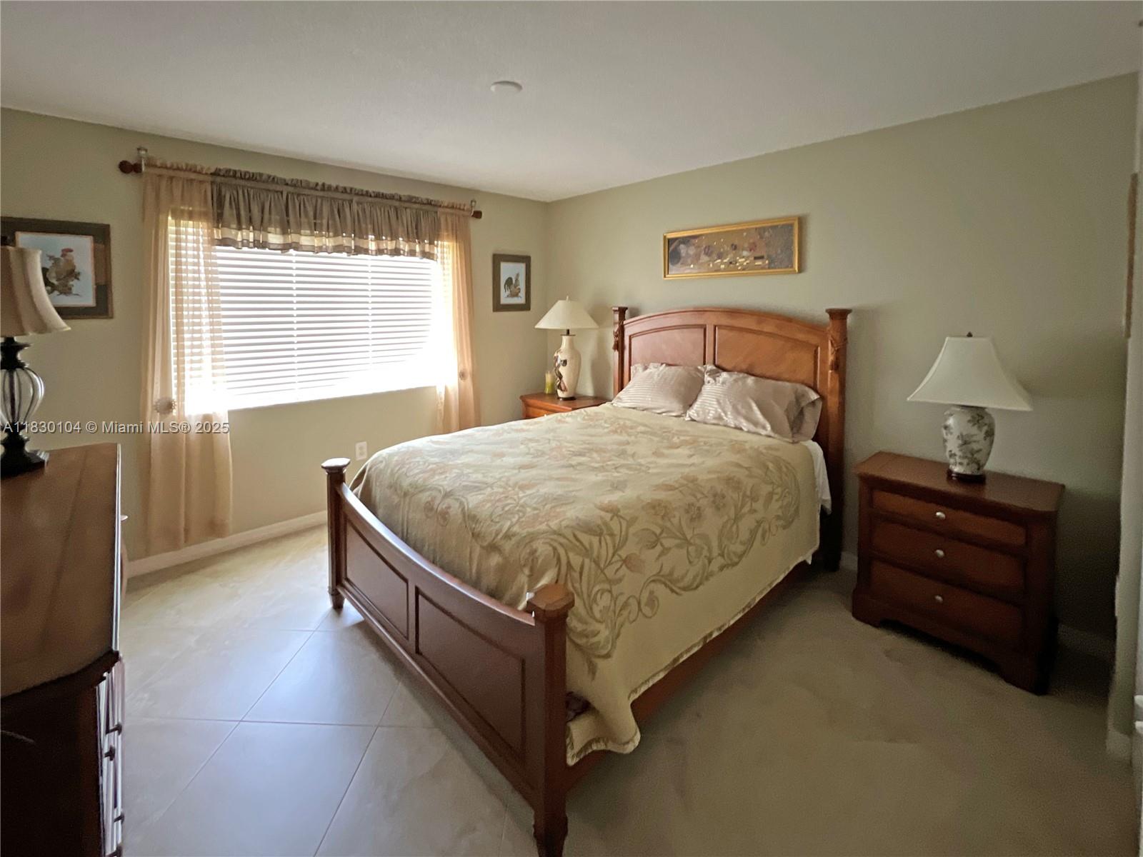3588 Northwest Adriatic Lane, Unit 202 Jensen Beach, FL 34957 - Photo 11 of 13 a bedroom with a bed and window