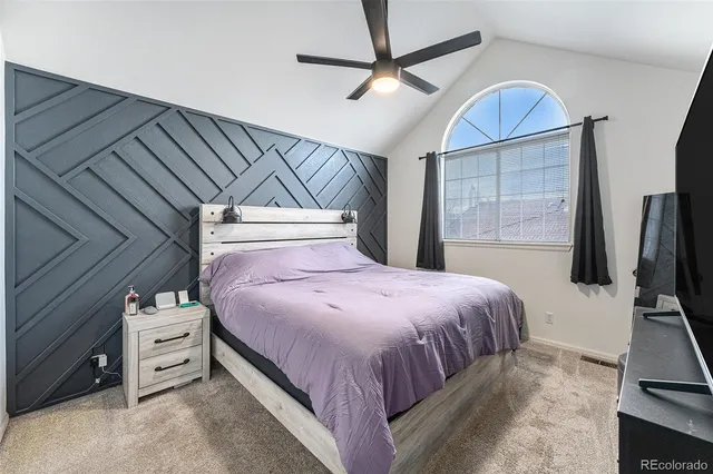 a bedroom with a large bed and a flat tv screen on dresser
