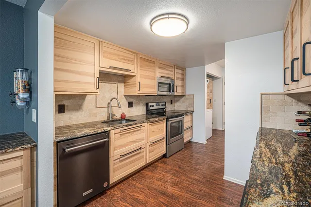 a kitchen with stainless steel appliances granite countertop a stove and a refrigerator