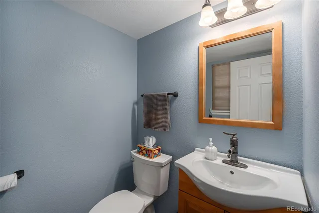 a bathroom with a sink mirror and toilet