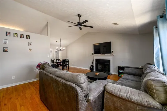 a living room with furniture a fireplace and a flat screen tv