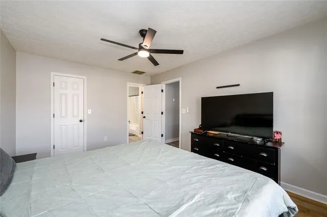 a bedroom with a bed and a flat tv screen on wall