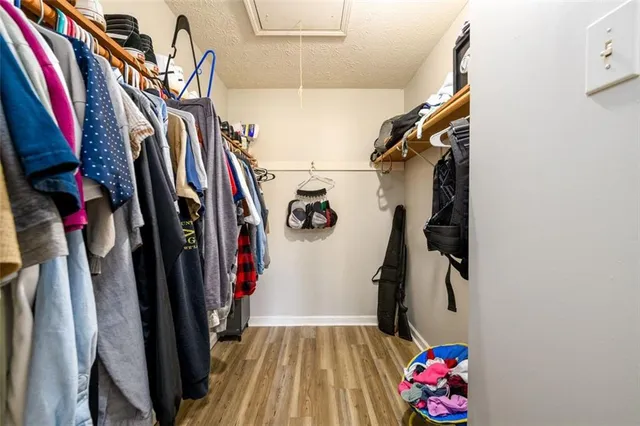 a view of walk in closet with clothes and shoes