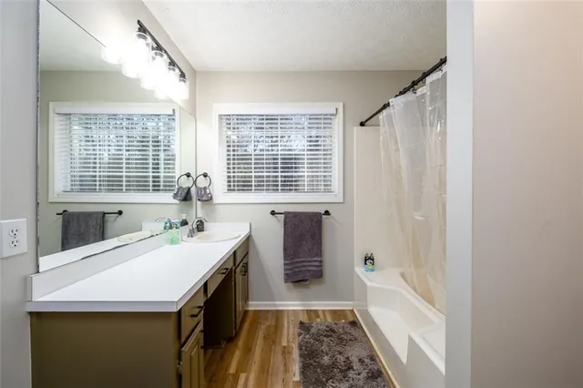 a bathroom with a sink a bathtub and next to a window