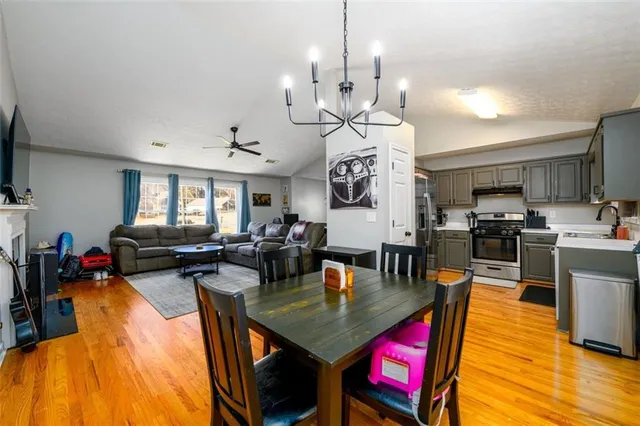 a view of a dining room and livingroom with furniture wooden floor a rug a chandelier